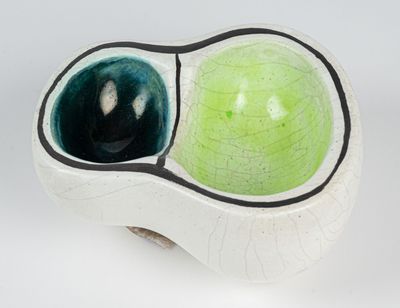a white bowl with a green apple inside of it