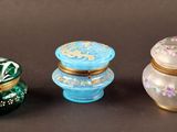Trois petits récipients en verre sont posés les uns à côté des autres sur une table.