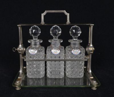 three glass bottles sitting on a metal stand