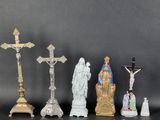 several figurines of jesus and other religious objects on a table