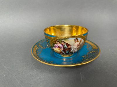 a cup and saucer with a painting on it