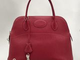 a red leather handbag with a lock on the handle