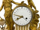 a gold clock with a statue on top of it