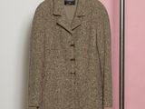 un manteau accroché à un porte-manteau devant un mur rose et blanc