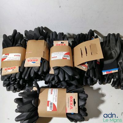 plusieurs paires de gants noirs posées sur une table blanche