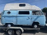 une camionnette bleue remorquée par une remorque à plateau