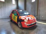 a small car that is painted with graffiti in a garage