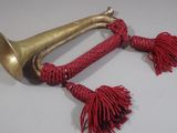 a brass trumpet with red tassels hanging from it