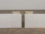 a pair of white marble blocks sitting on top of a wooden floor