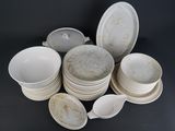 a lot of white plates and bowls on the table