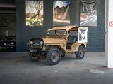 une vieille jeep garée dans un garage à côté d'autres voitures