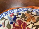 a plate with a flower design on it sitting on a table