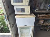two microwaves stacked on top of each other in a garage