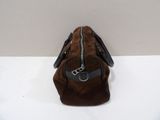 the small brown bag is sitting on a white surface