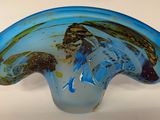 un vase en verre bleu orné d'un motif de vagues