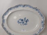 blue and white plate with flowers on it on a white surface
