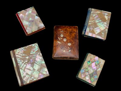 quatre petits livres sont disposés en cercle sur une surface noire