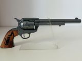 pistolet posé sur un socle en acrylique transparent, sur une surface blanche