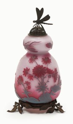 purple and pink vase with dragonfly on top of it