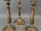 trois bougeoirs anciens en laiton sur fond blanc