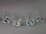 seven glasses lined up in a row on a table