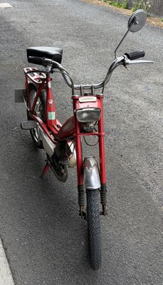 a red moped parked on the side of the road