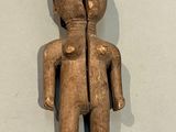 an old wooden figurine of a man with a broken face