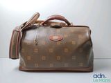 un sac marron et beige posé sur une surface blanche