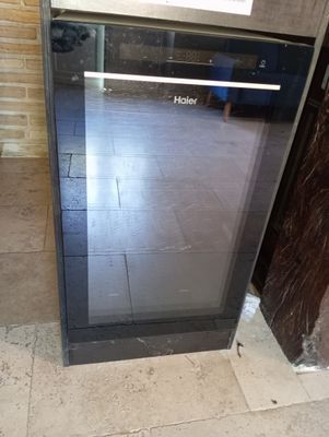 a black oven sitting in the middle of a tiled floor