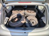 four tires in the back of a car with the trunk open