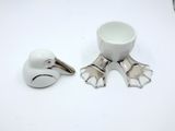 a white bird and a white cup on a table