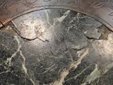 a close up of a marble table with a clock on top of it