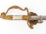 a sword with a gold handle on a white surface