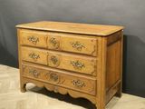 an antique chest of drawers on a chevroned wooden floor