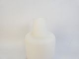 a white vase that is sitting on a white surface