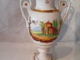 un vase blanc avec un tableau posé sur une table