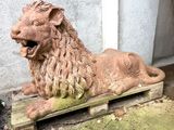 a statue of a lion sitting on a wooden platform
