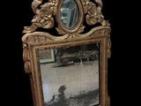 un miroir posé par terre devant un fond noir