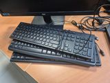 two keyboards and a computer monitor on a desk