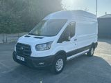 La camionnette blanche est garée sur le parking près des arbres.