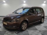 La camionnette marron est garée sur un sol en damier dans le garage.