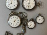 many different types of pocket watches displayed on the table