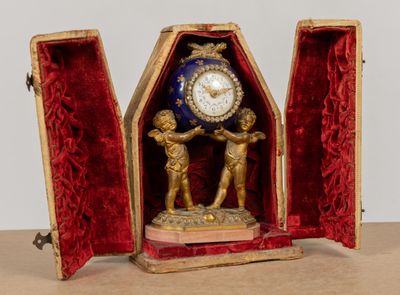 une horloge posée dans un boîtier sur une table