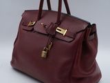 a close up of a red handbag on a white surface
