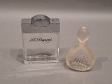 a small glass perfume bottle next to a small glass perfume bottle
