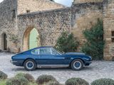 a blue car that is parked in front of a stone building