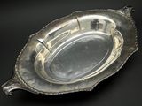 une assiette ancienne en argent sur fond noir, avec un fond noir