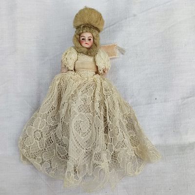 une poupée à l'ancienne avec une robe blanche et de la fourrure sur un fond blanc