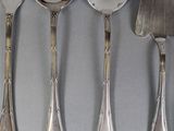 five silver spoons and a knife on a table