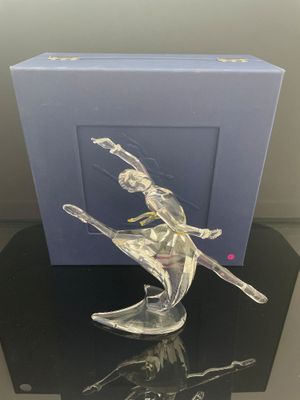 figurine représentant une femme sur une planche de surf, présentée dans une boîte